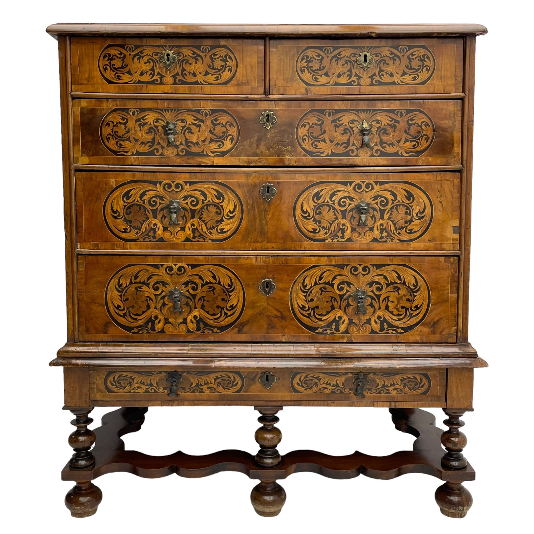 18th century inlaid walnut chest on stand, ovolo-moulded rectangular top inlaid with ebony panels each decorated with scrolling foliage, flower heads and birds, fitted with two short over three long drawers, the drawer fronts decorated with ebony panels enclosing curled leaf inlays, the base fitted with single drawer on turned supports united by waved stretchers, on turned bun feet 