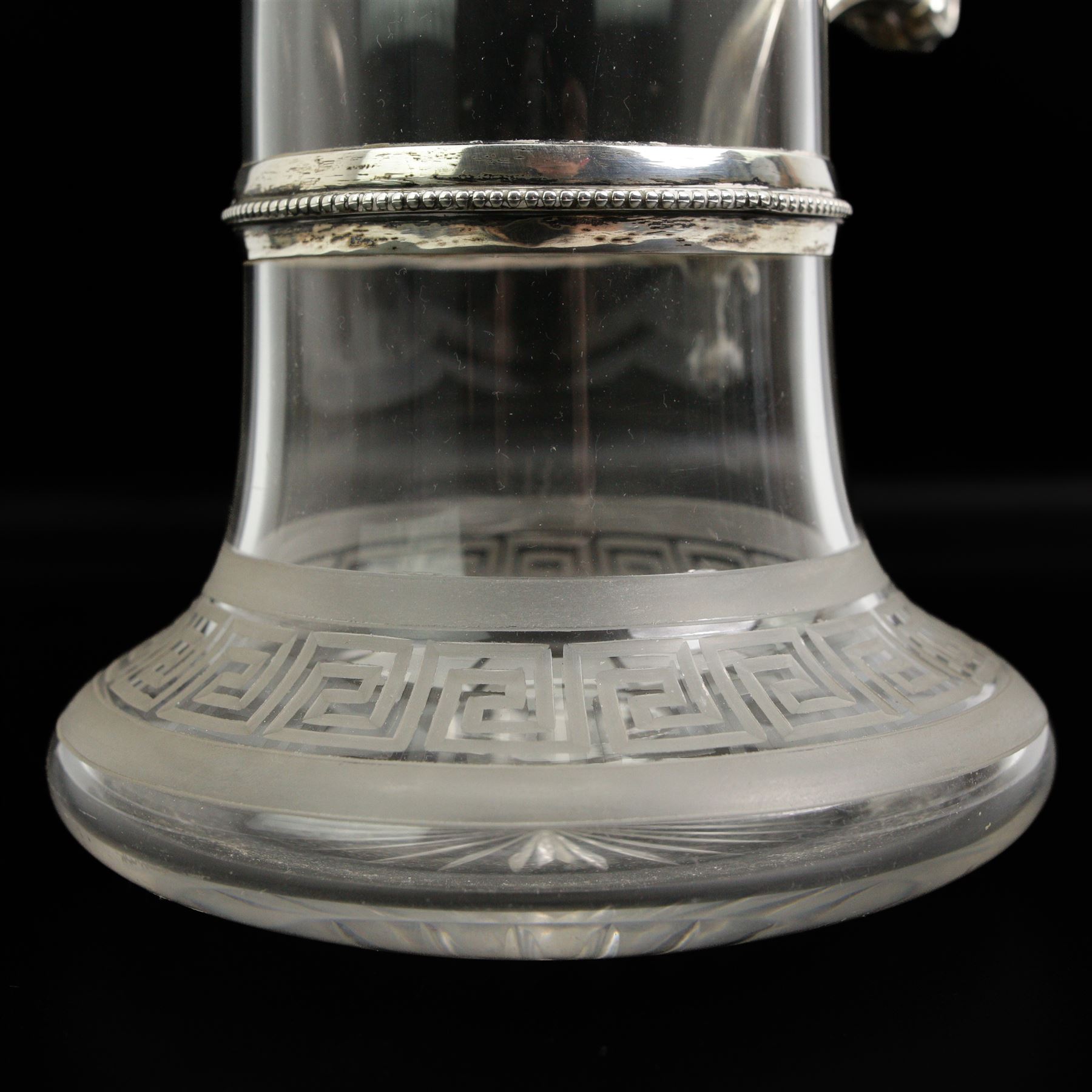 Victorian silver-mounted glass claret jug by George Richards Elkington, with Bacchanalian repoussé decoration and mask spout, with a domed hinged cover with a thumb-piece modelled as a rampant lion holding a shield, with engraved Dragon head crest, the glass body with etched greek key border and star-cut base, H29cm 