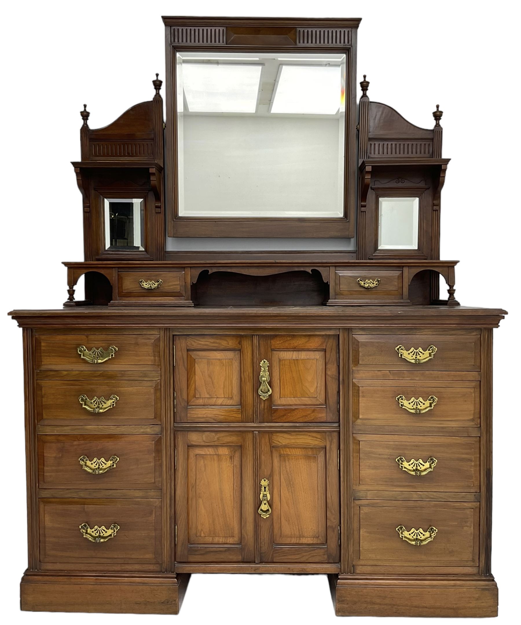 Edwardian mahogany dressing chest, raised triple mirror back with bevelled plates and fluted decoration over two trinket drawers, the base fitted with two central cupboards flanked by four graduating drawers to each side