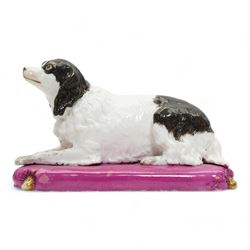 Mid 19th century Copeland & Garrett model of a recumbent spaniel upon a pink tasselled cushion, printed marks beneath, L20cm x H12cm