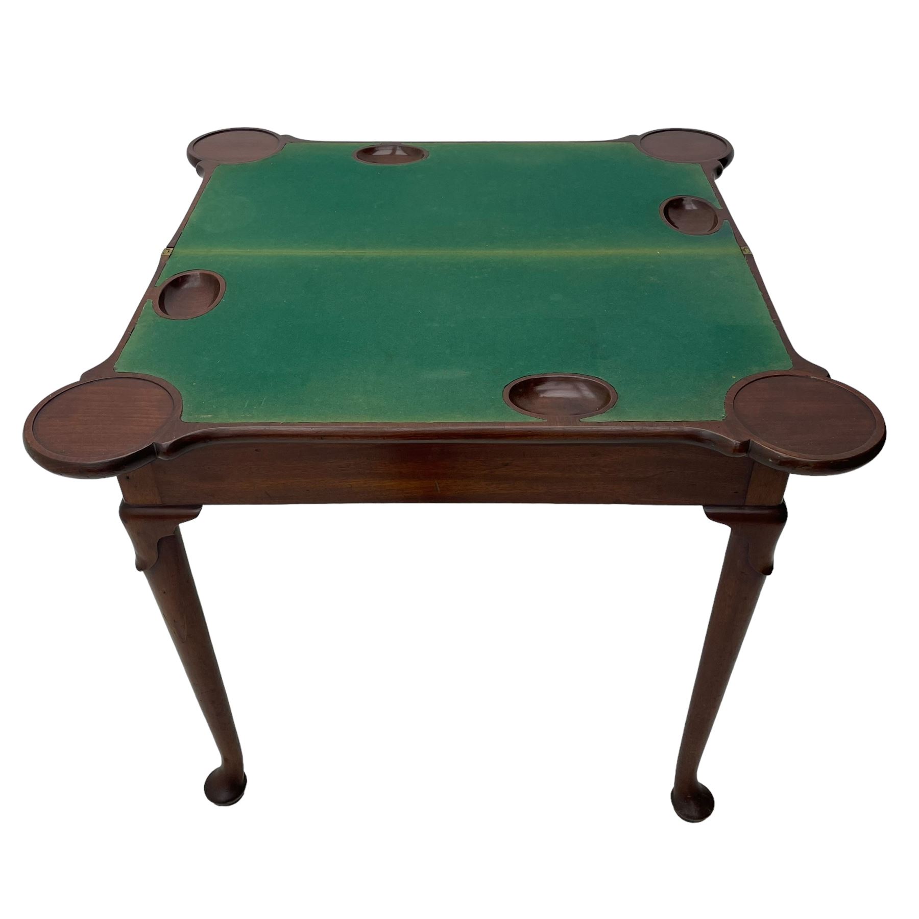 George III mahogany games table, the rectangular fold-over top with extending stepped rounded corners, opening to reveal baize lined interior with sunken counter wells, concertina action base, on lappet cabriole supports