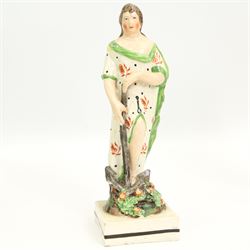 Three early 19th century Staffordshire Pearlware figures depicting Faith, Hope and Charity, Faith standing next to a shield bearing a cross, on an oval encrusted and moulded base H20cm, Charity stood holding a child and another by her side and Hope standing with an anchor, both on square bases (3)