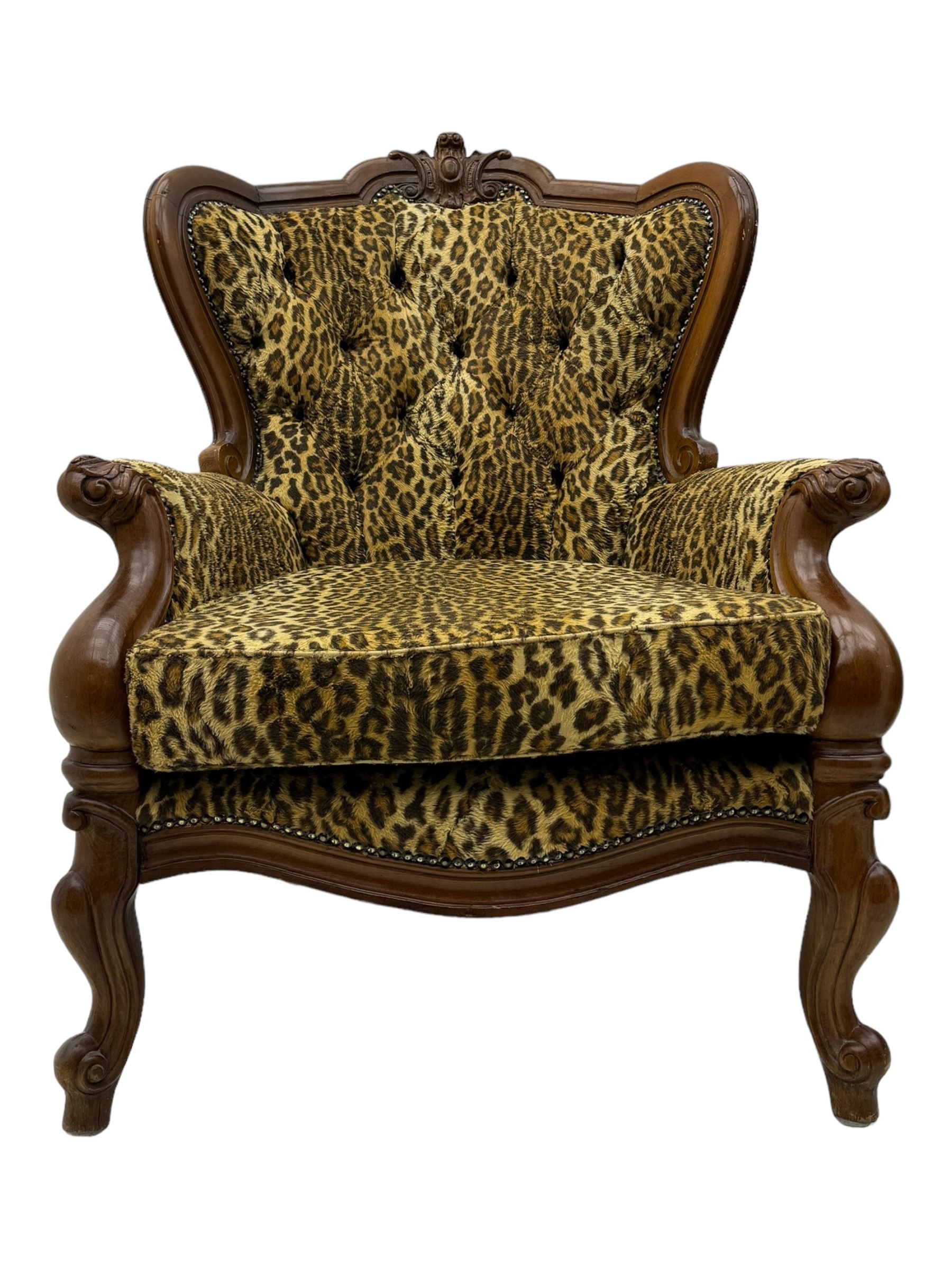 Pair of Victorian design stained beech armchairs, upholstered in leopard print fabric, with carved top rail over button-tufted backrest, scroll arms, serpentine front rail, raised on cariole supports