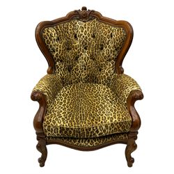 Pair of Victorian design stained beech armchairs, upholstered in leopard print fabric, with carved top rail over button-tufted backrest, scroll arms, serpentine front rail, raised on cariole supports