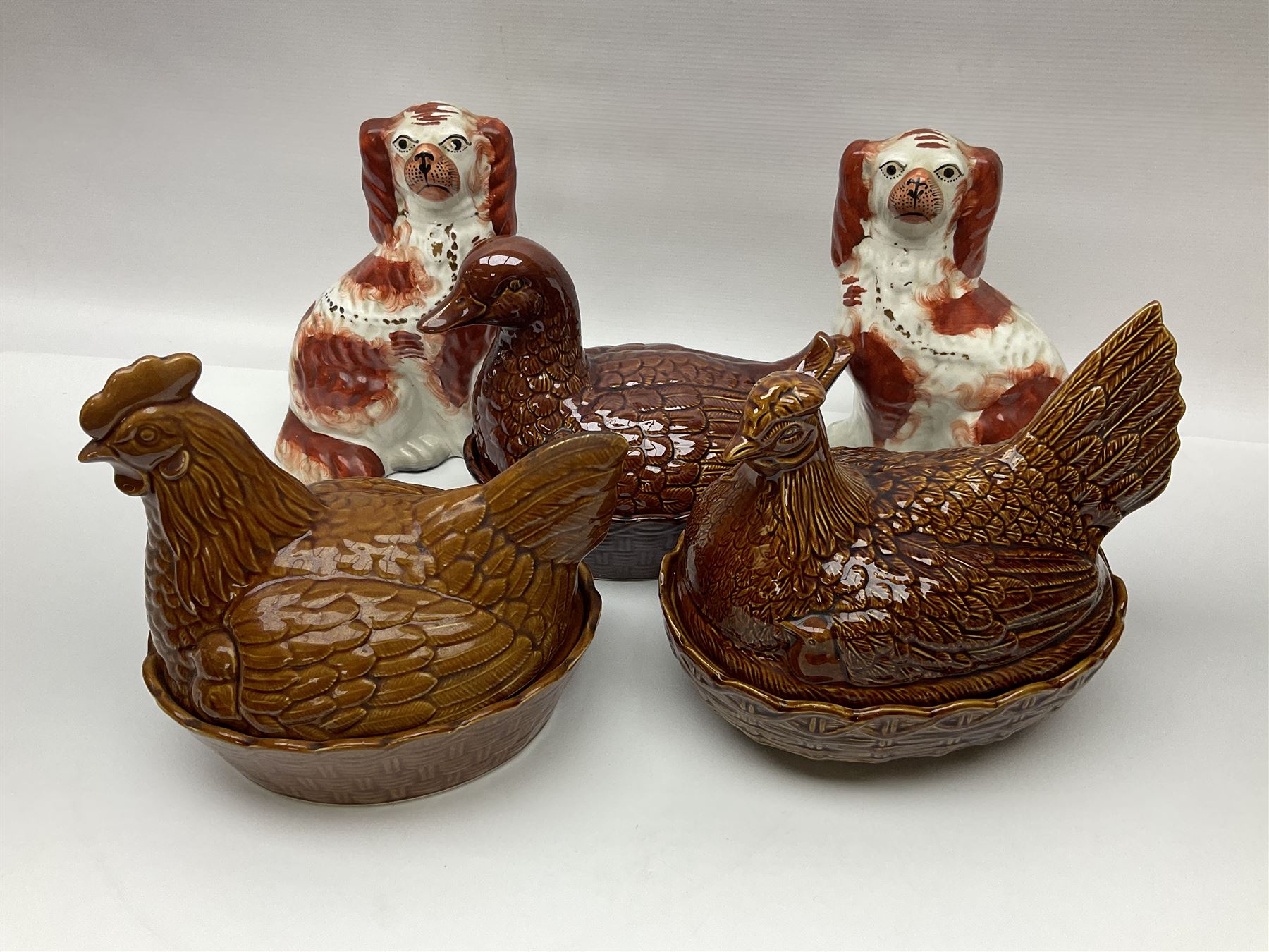 Two hen on nest, together with duck on nest and two staffordshire style dogs 