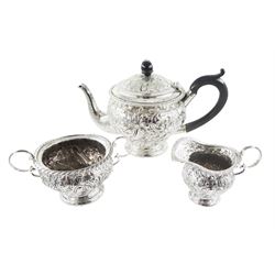 Late Victorian silver three piece bachelors tea service, comprising teapot, open sucrier and milk jug, each of bellied form, upon a circular stepped foot, and profusely embossed with foliate and scrolling decoration, the teapot with ebonised handle and finial, hallmarked George Nathan & Ridley Hayes, Birmingham 1894, teapot H14.5cm