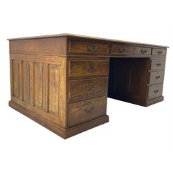 Large 20th century oak twin pedestal desk, moulded rectangular top over nine drawers, panelled pedestals, on moulded plinth base 