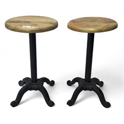 Pair of 20th century machinist stools, each with height-adjustable beechwood circular seats, supported by cast iron pedestal bases with four splayed feet