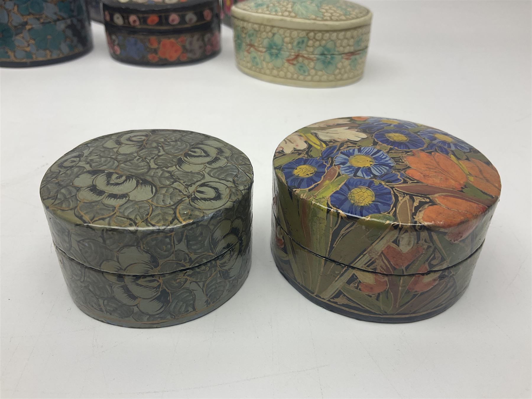 Twelve lacquered boxes, to include square and oval examples, with floral decorations, tallest H5cm