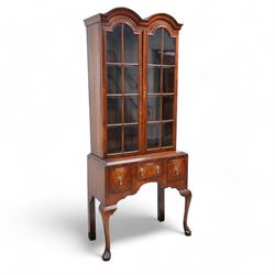 George II design walnut cabinet on stand, double arched top with applied mouldings over two astragal glazed doors, three internal shelves, the stand with moulded rectangular top fitted with three short drawers over shaped apron, on cabriole front supports 