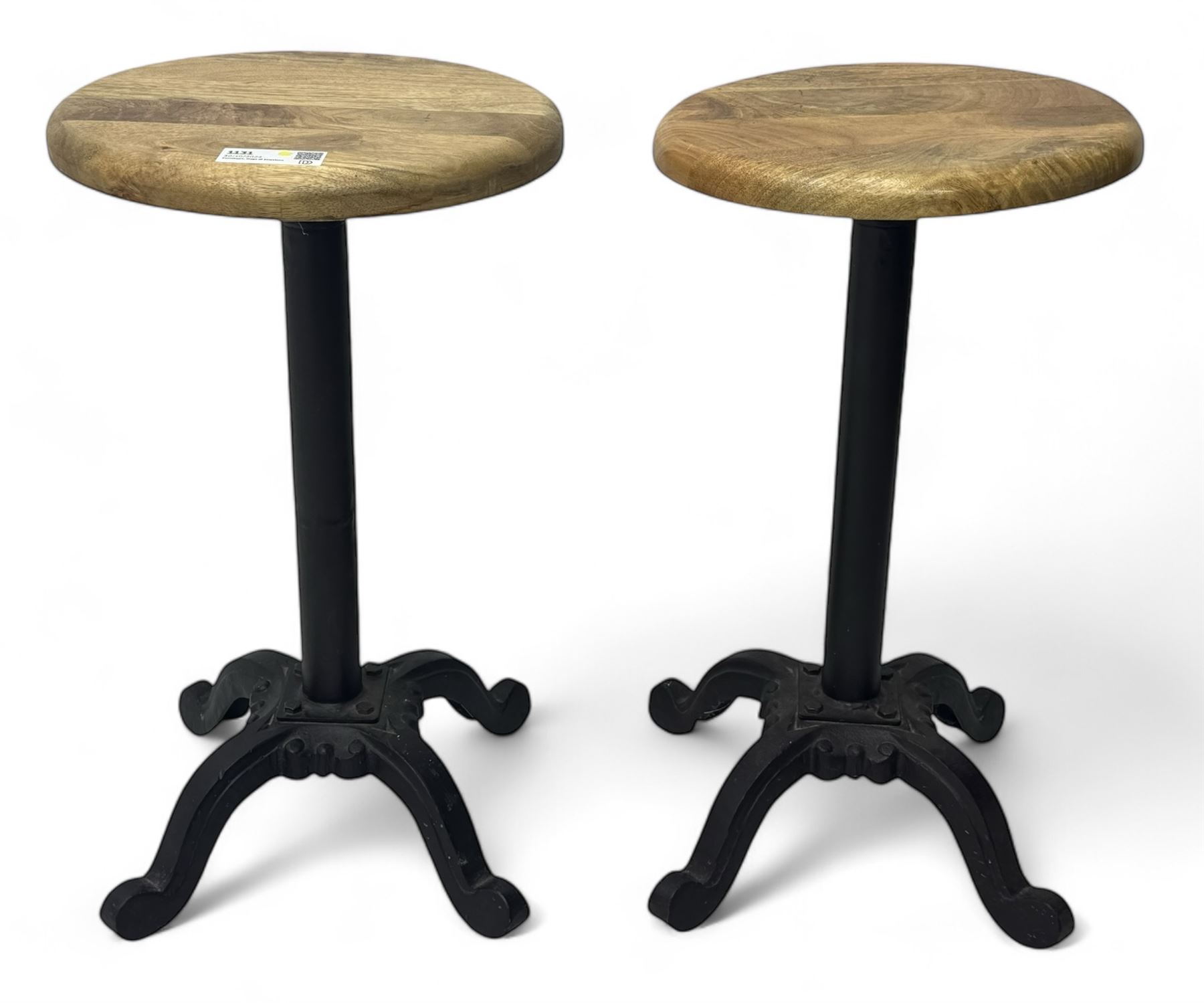 Pair of 20th century machinist stools, each with height-adjustable beechwood circular seats, supported by cast iron pedestal bases with four splayed feet