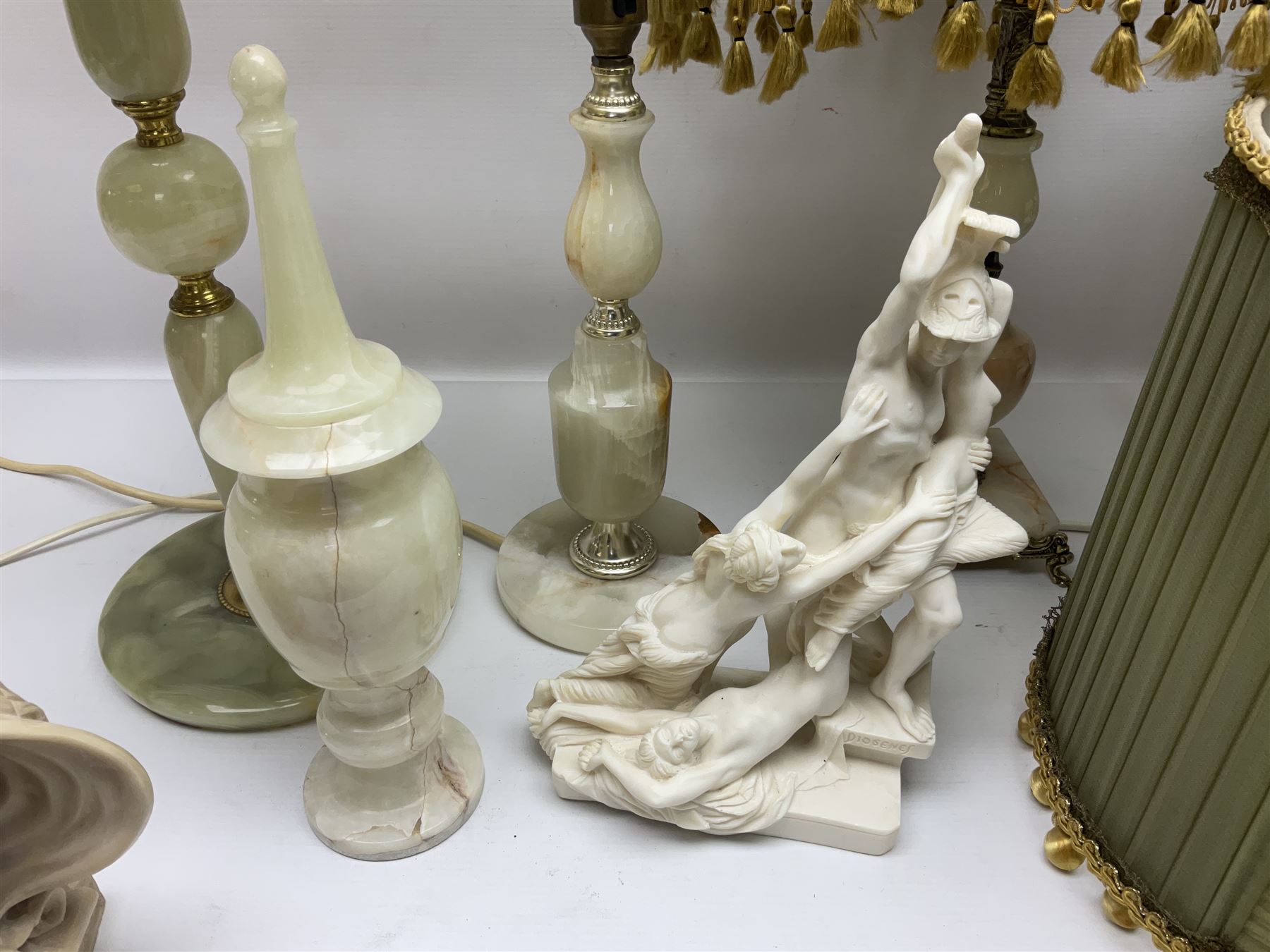 Onyx table lamp, with knopped stem and cream and green tassel shade, together with three smaller similar onyx lamps, classical style alabaster figures and a covered onyx jar