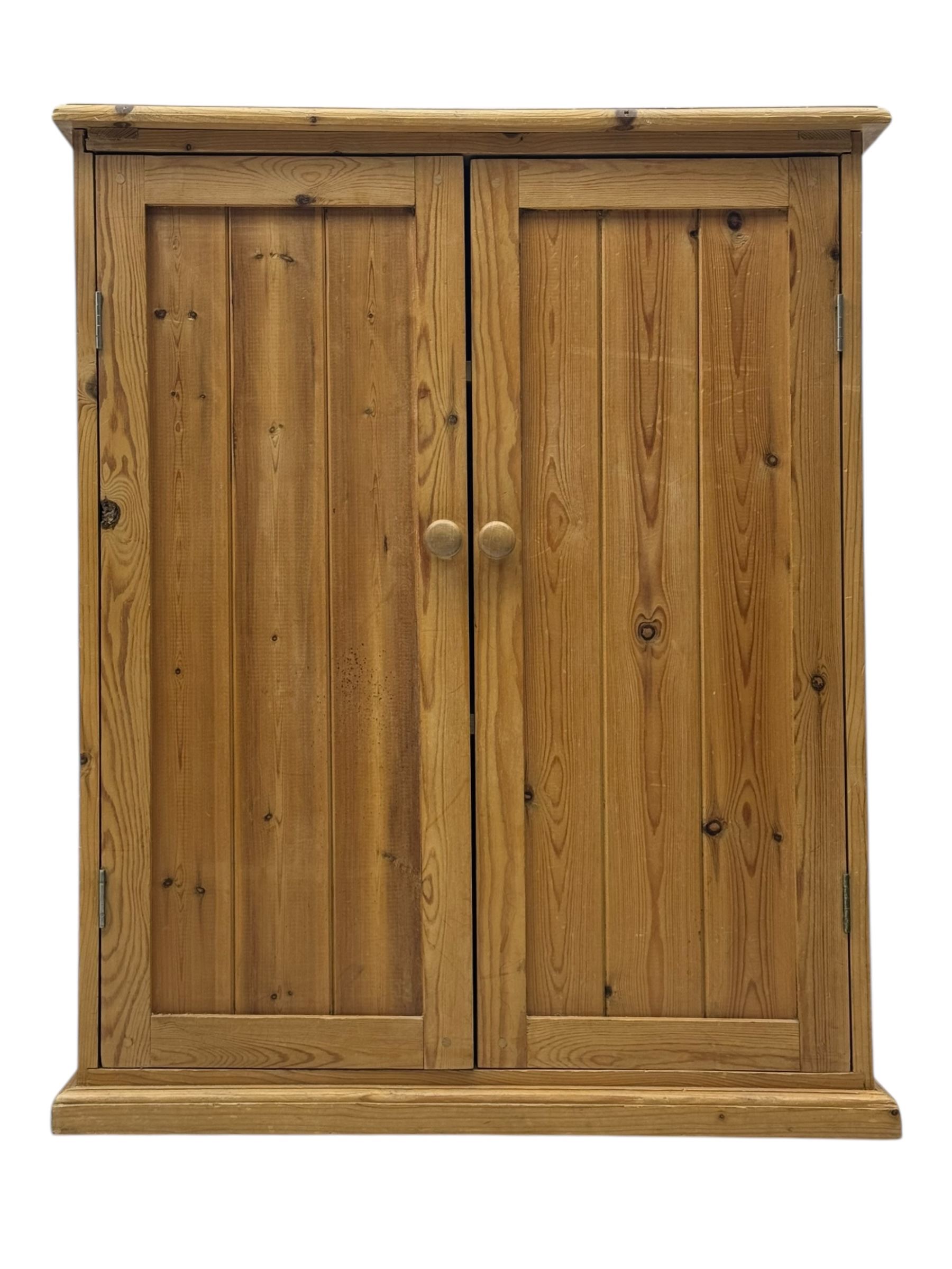 Pine cupboard, rectangular moulded top over two panelled doors enclosing two plank shelves, on plinth base