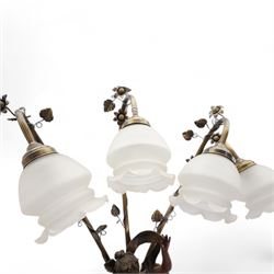 Pair of large bronzed resin figural table lamps, modelled as a young woman and cherub, issuing three naturalistic branches, entwined with flowering tendrils, with three frosted glass shades, on simulated marble base, H84cm (2)