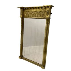 Regency giltwood and gesso pier mirror, projecting cavetto cornice with ball mounts, the frieze decorated with pointed arcade and foliate motifs, plain mirror plate enclosed by cluster column pilasters 