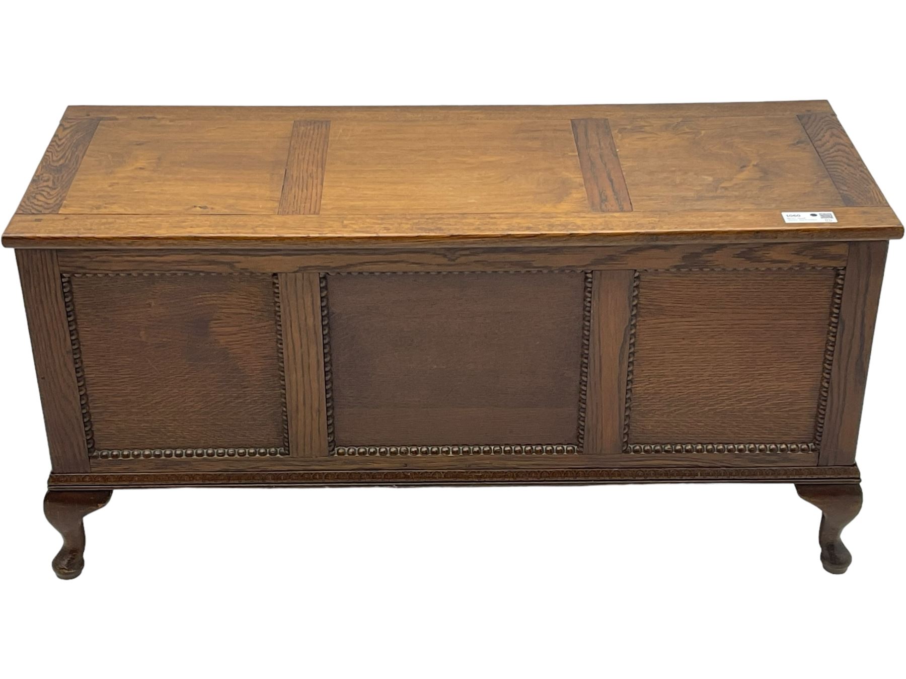 Early 20th century oak blanket chest, rectangular hinged lid with decorative panelling, the front and sides adorned with beaded panels, on cabriole feet