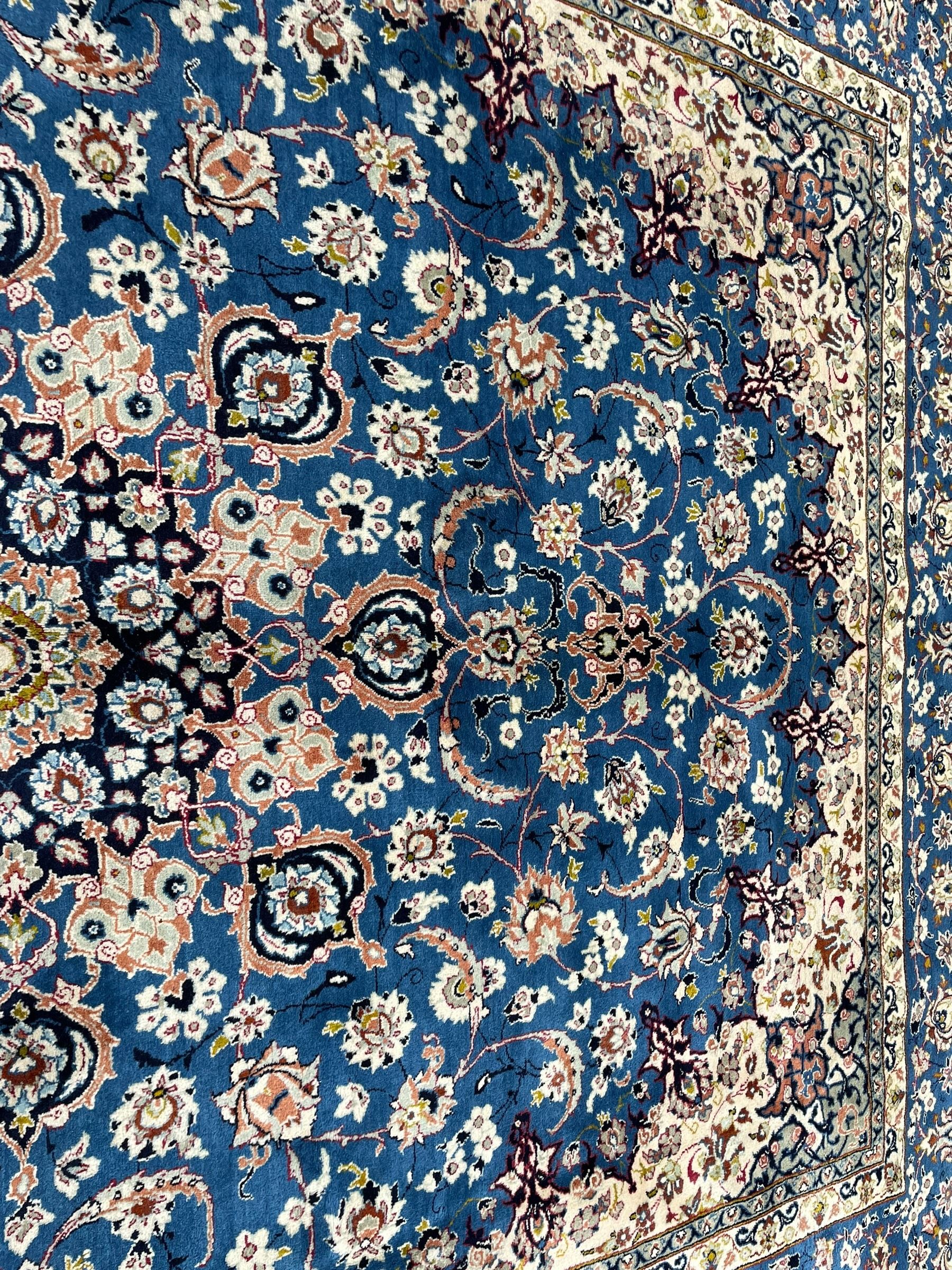 Persian Nain blue ground carpet, overall arabesque design, centre rosette medallion with eight projecting palmettes, the surrounding field decorated with interlacing branches and stylised plant motifs, within floral pale ground spandrels, the guarded border decorated with repeating stylised floral pattern 