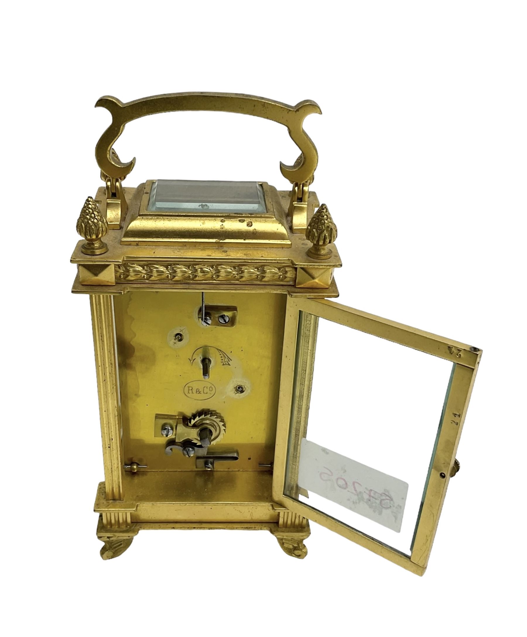 Early 20th century French carriage clock - 8-day timepiece movement in a decorative case with bevelled glass panels, white enamel dial with Roman numerals, minute markers and steel hands, retailed by Smith and Son, Scarborough, original lever platform escapement, with key.