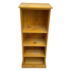 Narrow pine open bookcase, rectangular top over three shelves, on plinth base