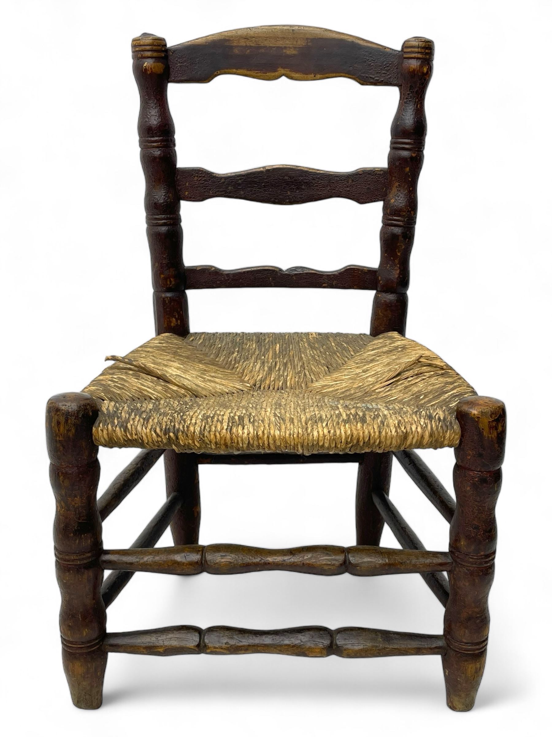 19th century painted elm primitive fire side chair, ladder back over rush seat, on turned supports united by turned stretchers 