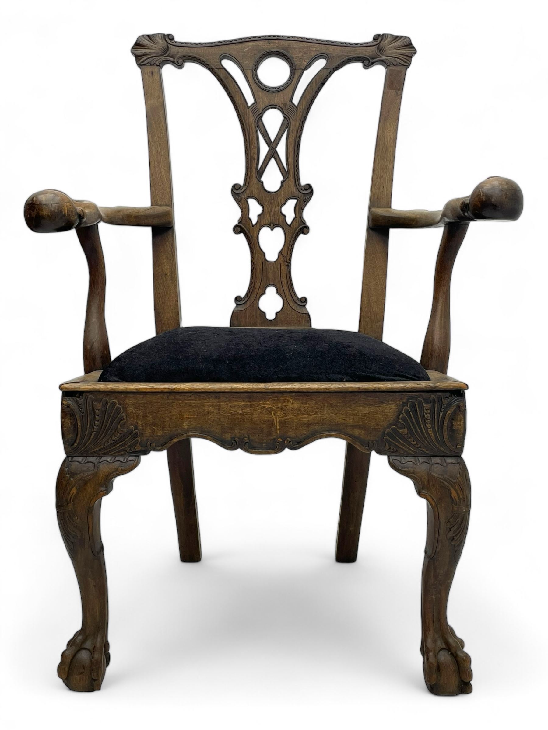 Unusual 18th century mahogany elbow chair, the shaped cresting rail with projecting shell carved ears, pierced and scroll carved splat over drop-in upholstered seat, shaped arms with ball and claw carved terminals, the seat rails carved with shell cartouches, on foliate carved cabriole supports with ball and claw feet 