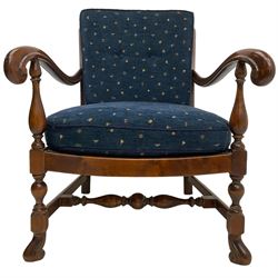 Early 20th century stained beech framed armchair, cane panel back over scrolled arm terminals, raised on turned supports united by turned H-stretcher, with patterned blue upholstered loose back and seat cushions