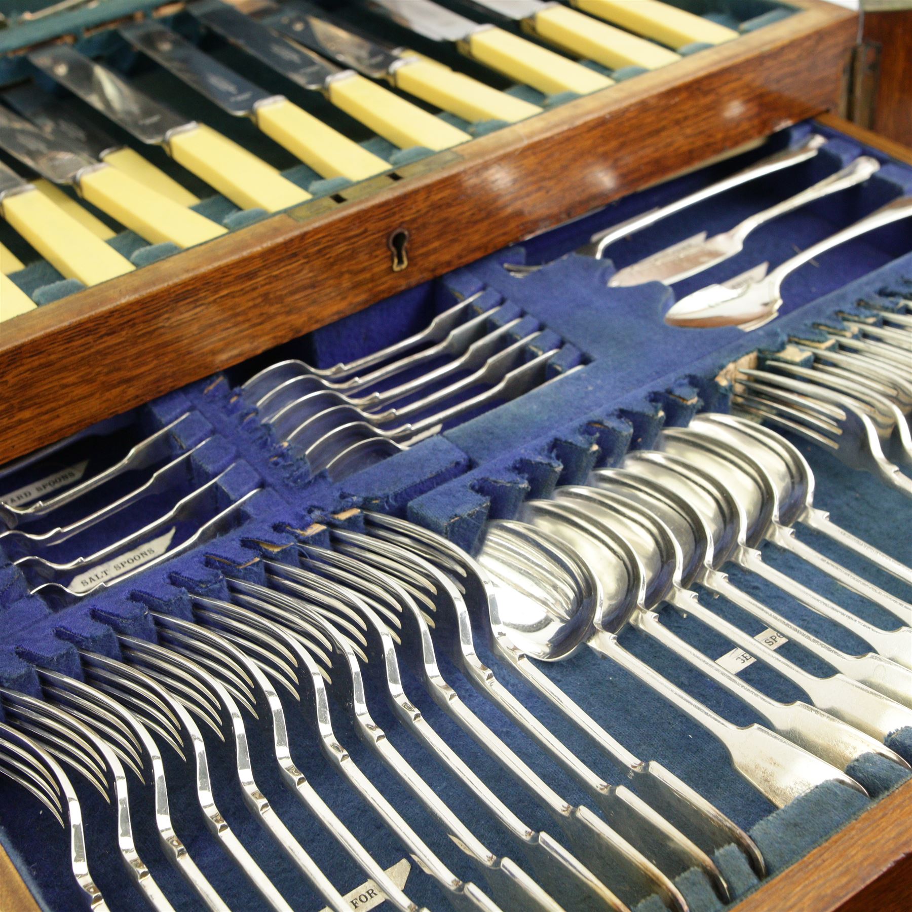 Wellington type oak canteen of silver plated cutlery, by J H Potter, Sheffield for twelve covers, including carving set, nut crackers, ladles, berry spoons, jam spoons, egg spoons, salt spoons, serving and dining cutlery, ivorine handles (incomplete)