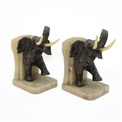 Pair of Art Deco onyx and bronzed spelter bookends modelled as two marching elephants with ivory tusks, H22cm This item has been registered for sale under Section 10 of the APHA Ivory Act