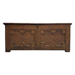 18th century oak blanket box, rectangular form with a hinged lid, the front decorated with raised geometric panelled mouldings, fitted with a central lock plate, raised on bracket feet