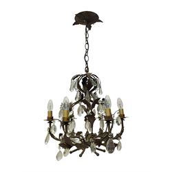 Early 20th century wrought metal chandelier, of scrolled form with six branches, decorated with leafage and glass pendants 