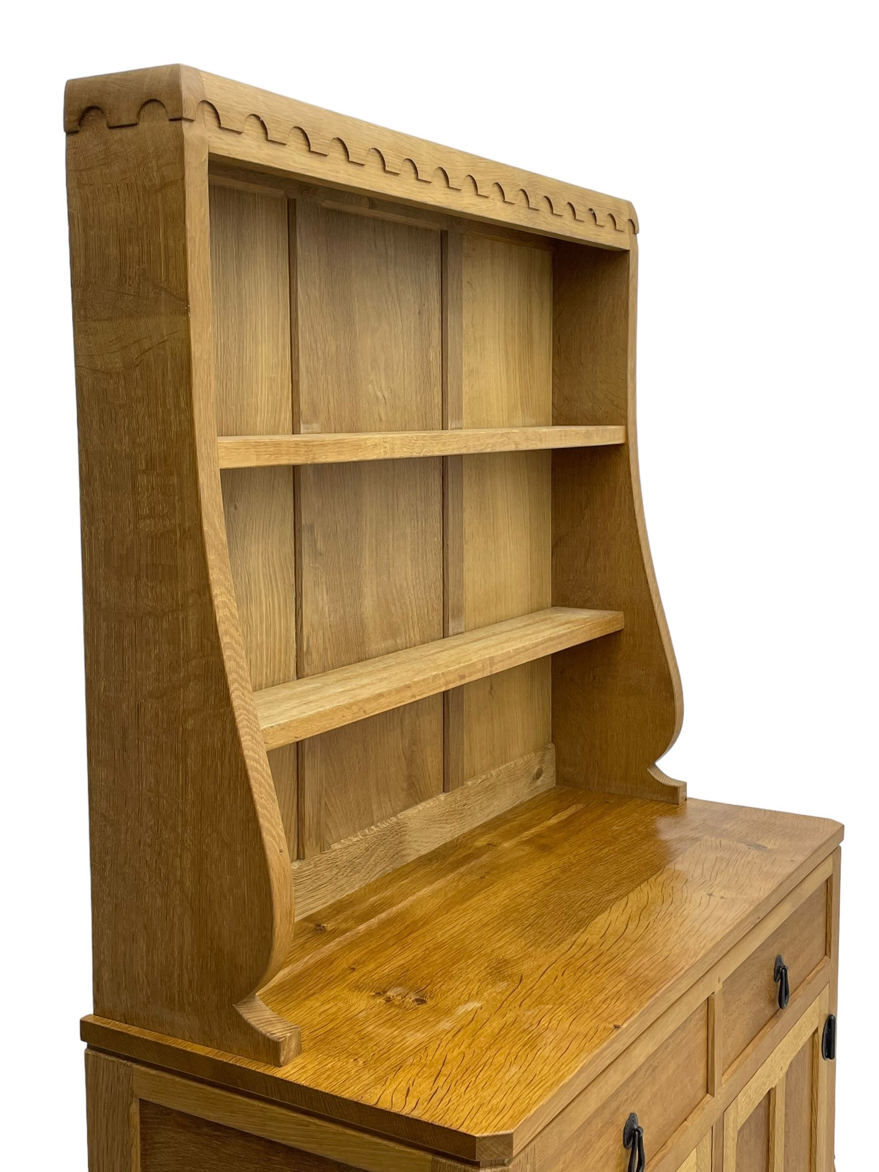 Mouseman - oak dresser, penny moulded cresting rail over two shelves supported by shaped ends, canted rectangular adzed top, fitted with two drawers and panelled cupboards, with wrought iron hinges and catches, on octagonal feet, carved with mouse signature, by the workshop of Robert Thompson, Kilburn 