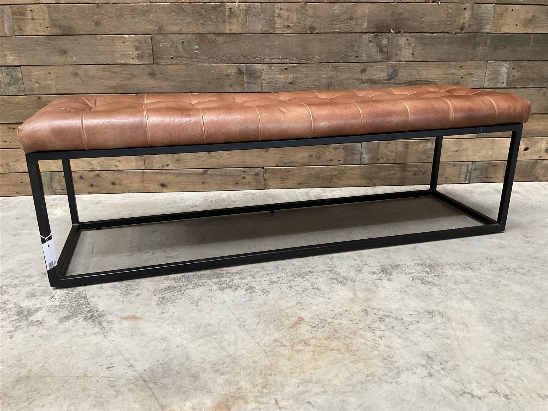 Two rectangular metal framed benches, upholstered in buttoned tan leather