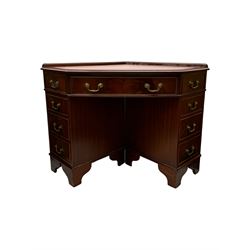 Late 20th century mahogany corner desk, leather inlaid top with gilt tooling, central frieze drawer flanked by two banks of four graduated drawers, raised on shaped bracket supports 