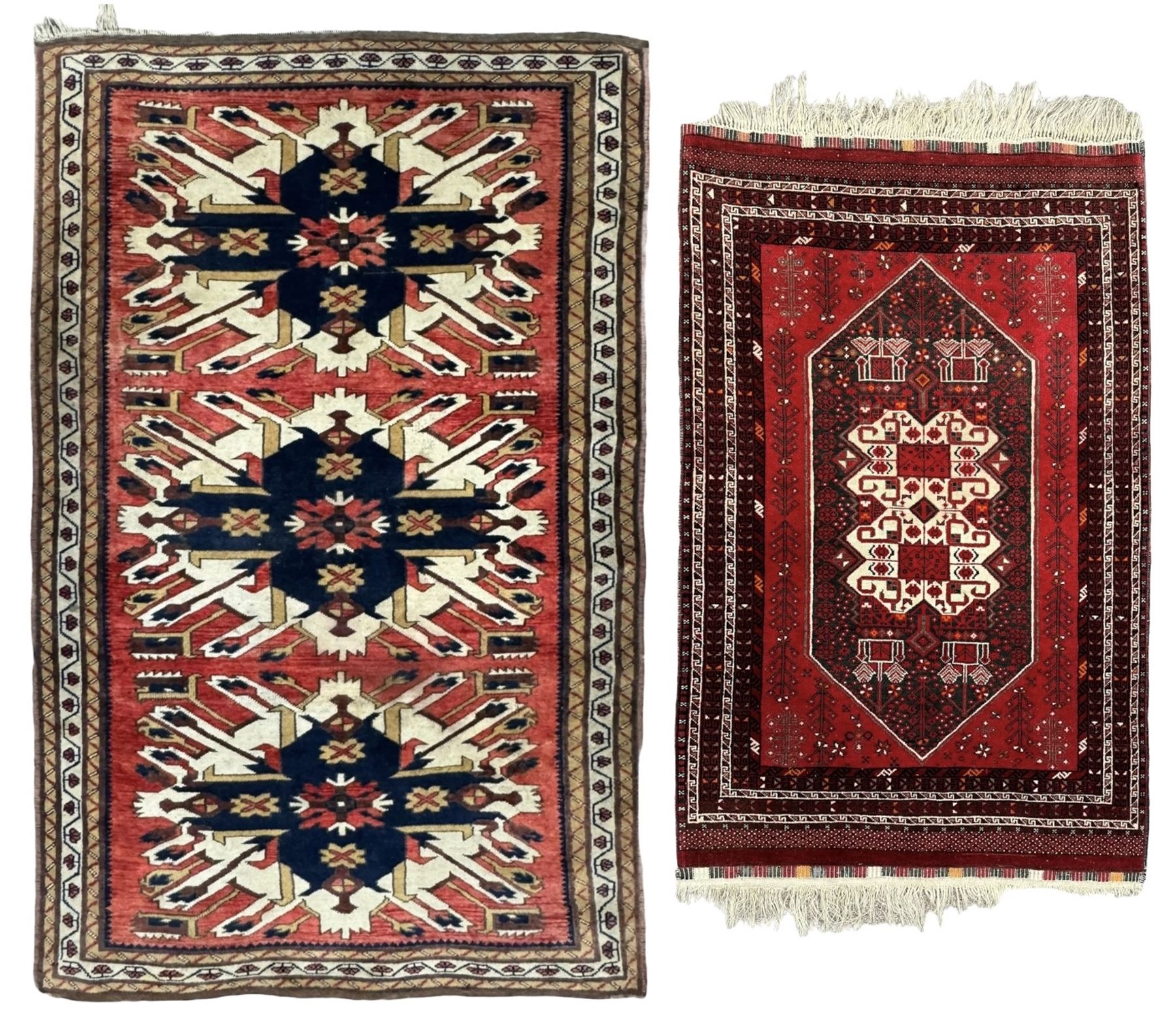 Persian Heriz red ground rug, the field with three large central medallions in indigo and ivory, border with geometric pattern within multiple guard stripes (119cm x 189cm); Persian Yomut crimson ground rug, central field with ivory medallion with geometric motifs, main border with geometric pattern within multiple guard stripes (88cm x 133cm)