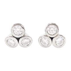 Pair of white gold bezel set, round brilliant cut diamond cluster stud earrings, total dia...