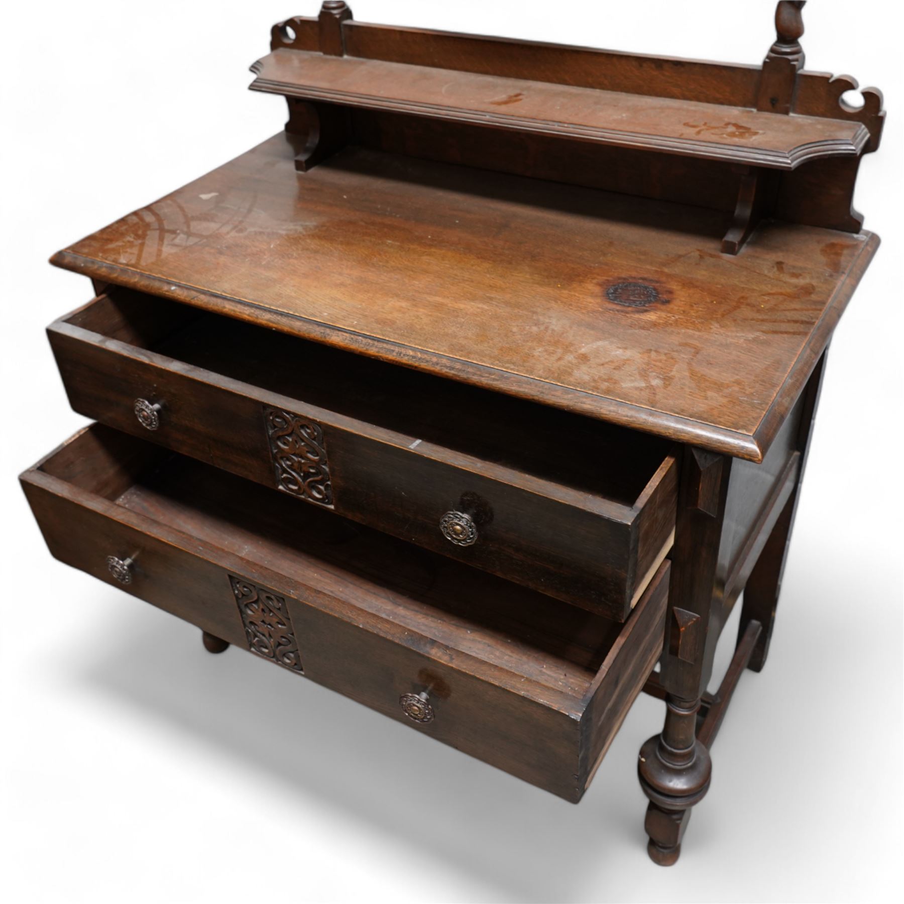 Art Nouveau oak dressing table, raised circular bevelled mirror on spiral turned supports, fitted with two drawers with scrolling foliate carvings, on turned supports joined by stretchers