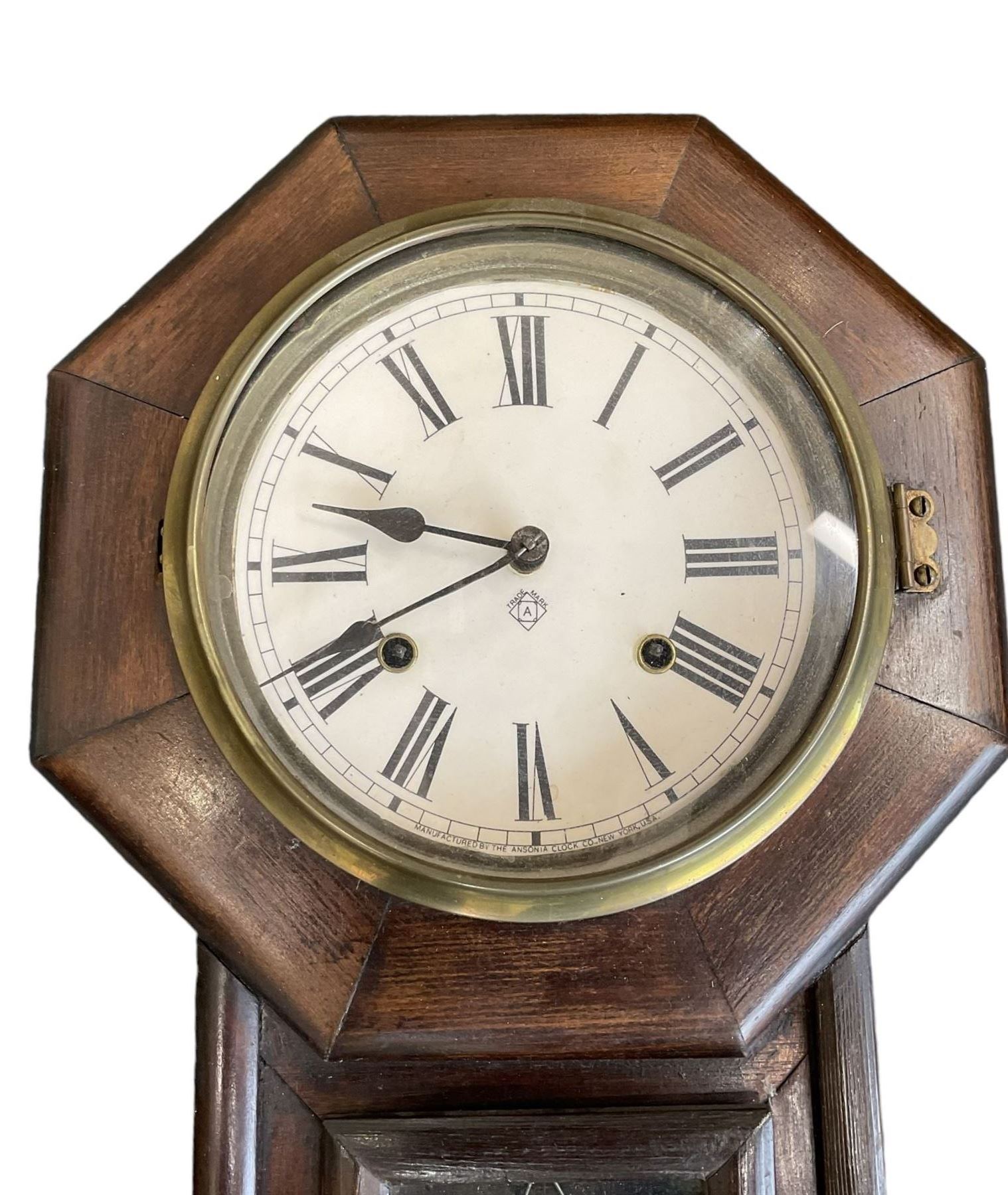 Ansonia- American 8-day oak cased drop dial wall clock with a octagonal dial frame and visible pendulum, striking the hours on a gong.