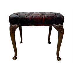 Chesterfield three-seat sofa, traditional shaped upholstered in deeply buttoned dark red leather; together with similar footstool 