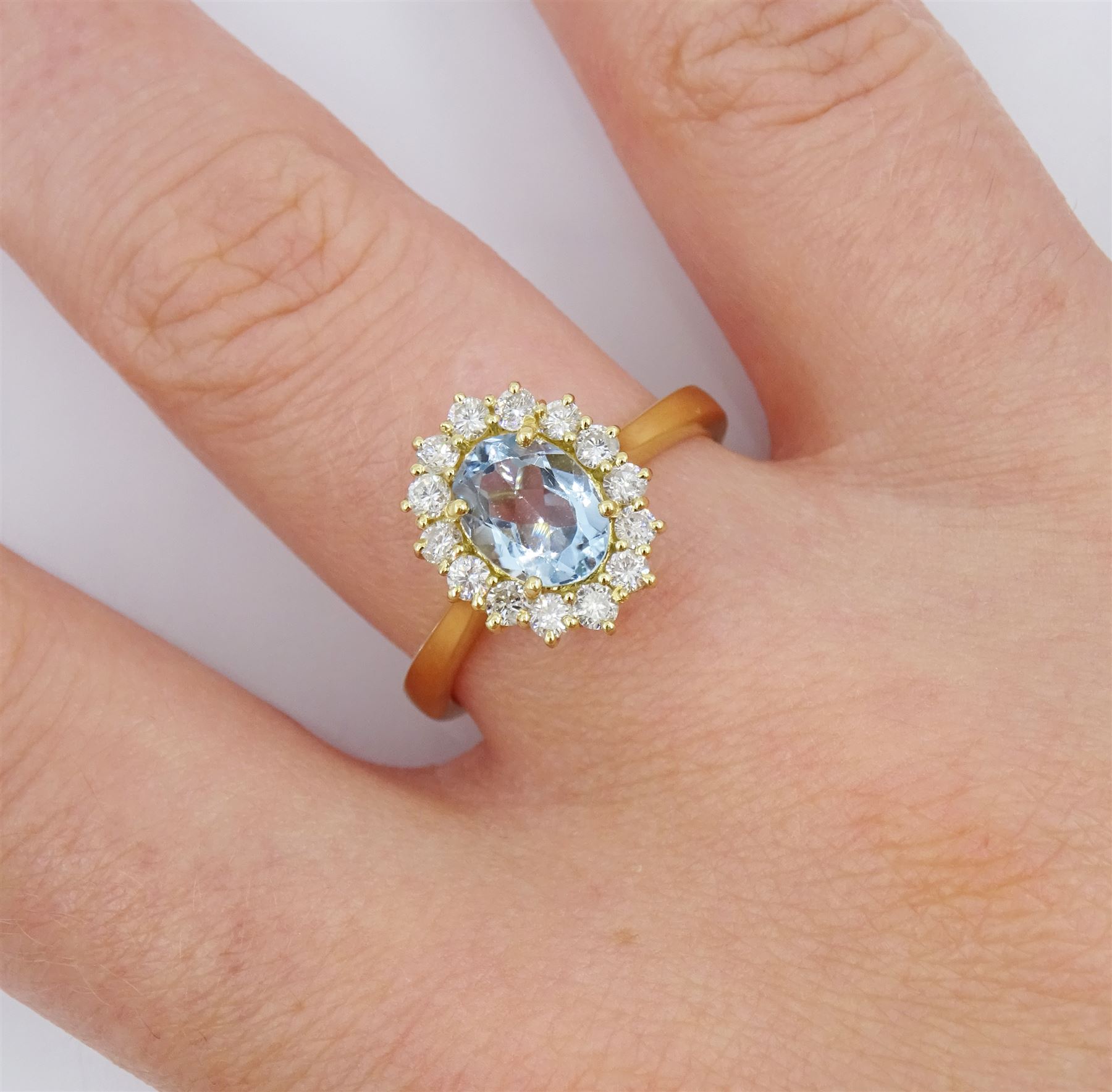 18ct gold oval cut aquamarine and round brilliant cut diamond cluster ring, hallmarked, aquamarine approx 0.85 carat, total diamond weight approx 0.40 carat