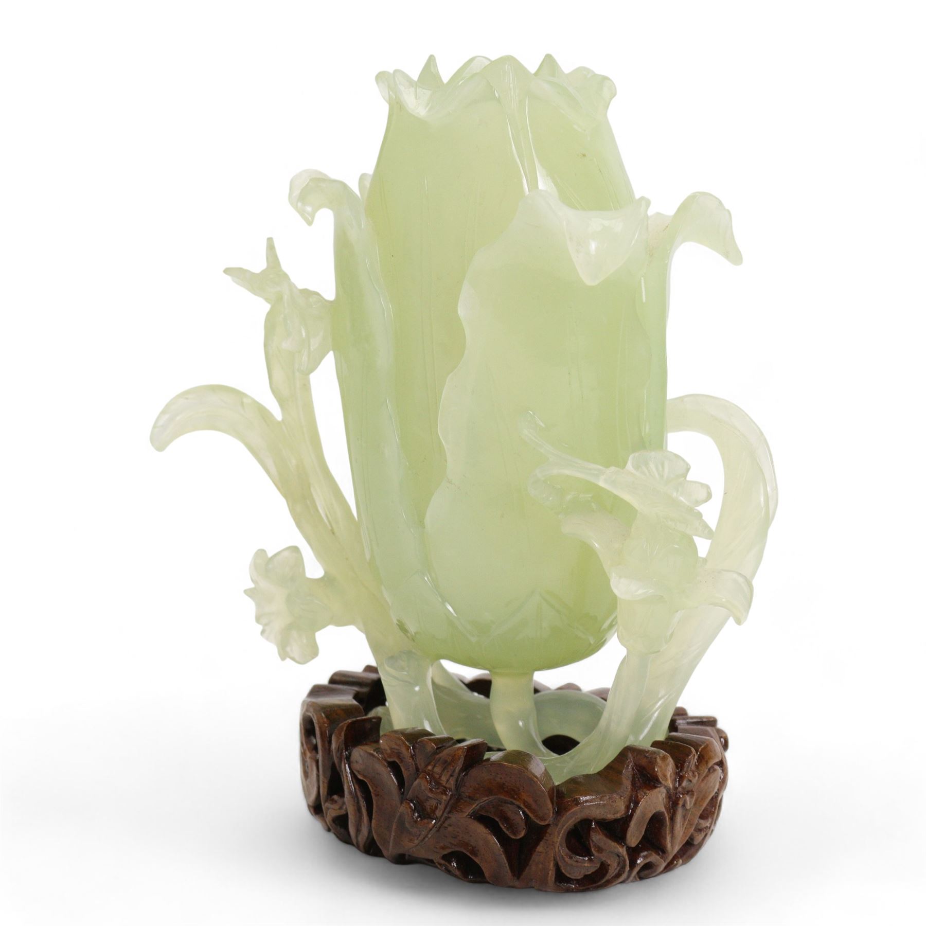 Chinese green jade magnolia form vase, supported on a leafy stem, with flowers and butterflies, on a pierced and carved hardwood stand, H15cm x W14cm