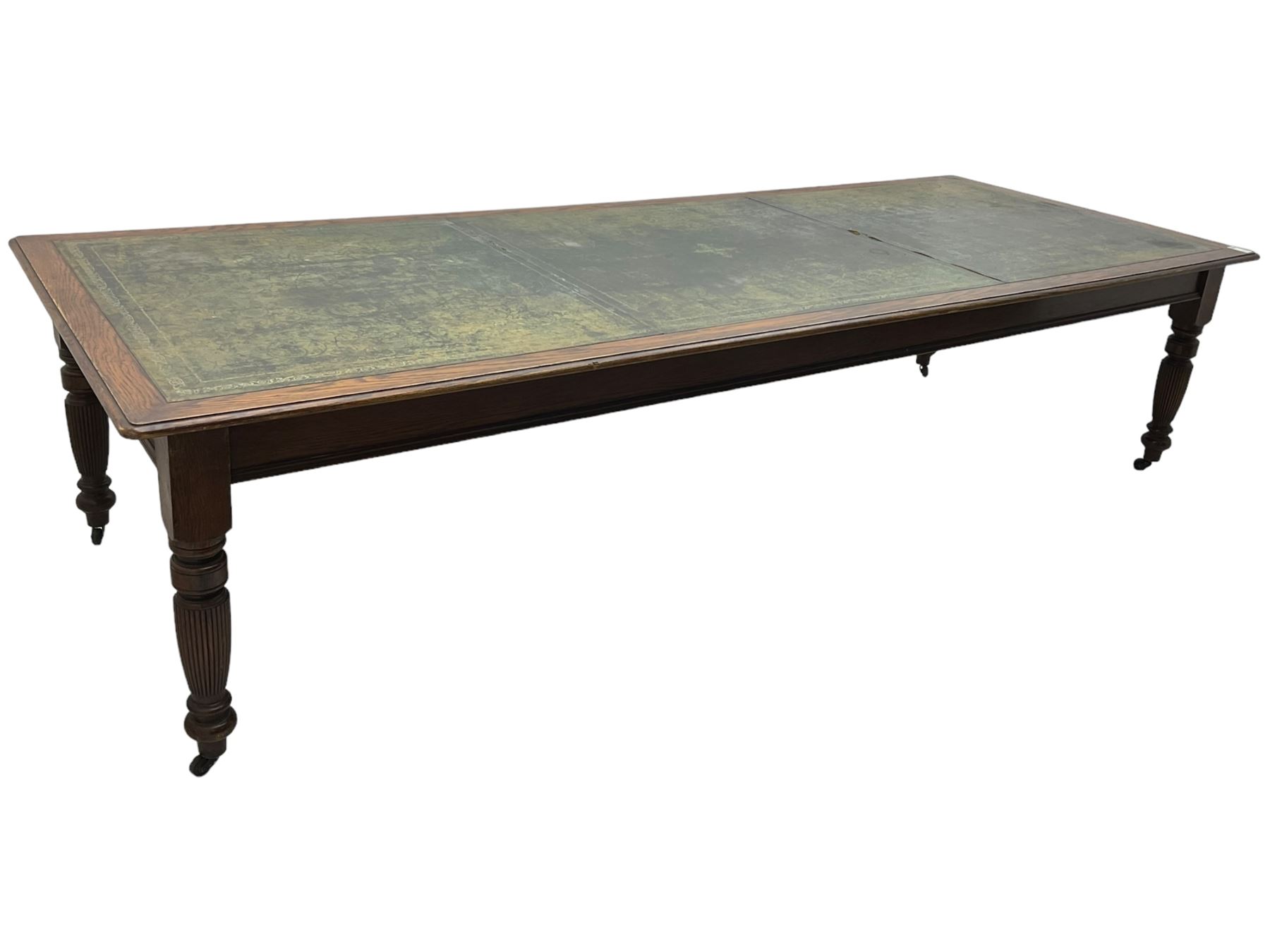 Large 10' 7'' late Victorian oak boardroom table, moulded rectangular top with inset green leather surface, on turned and reed moulded supports with brass and ceramic castors 