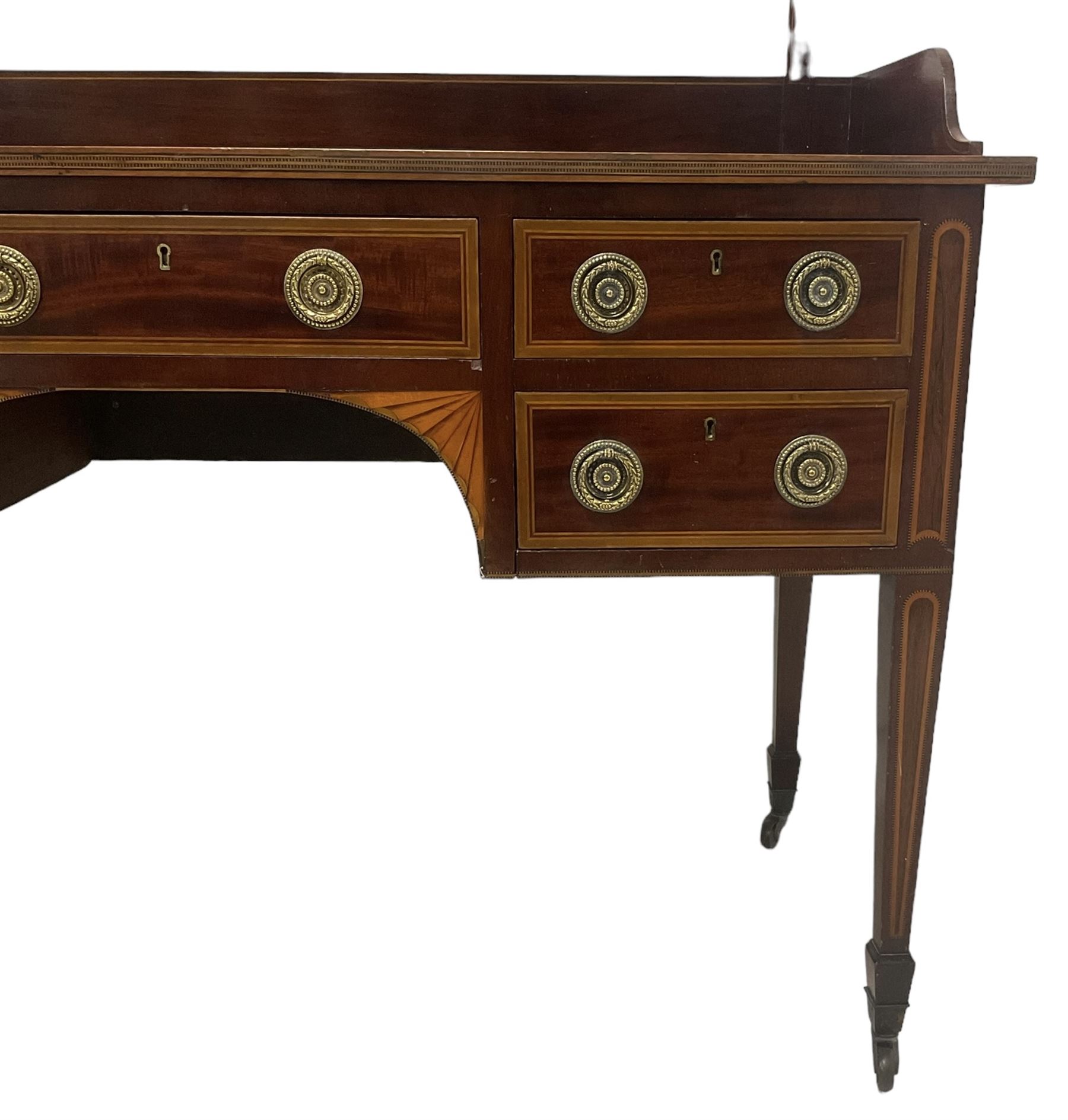 Edwardian inlaid mahogany kneehole dressing table, raised shaped oval bevelled mirror back, fitted with five drawers with banding and stringing, on square tapering supports with castors