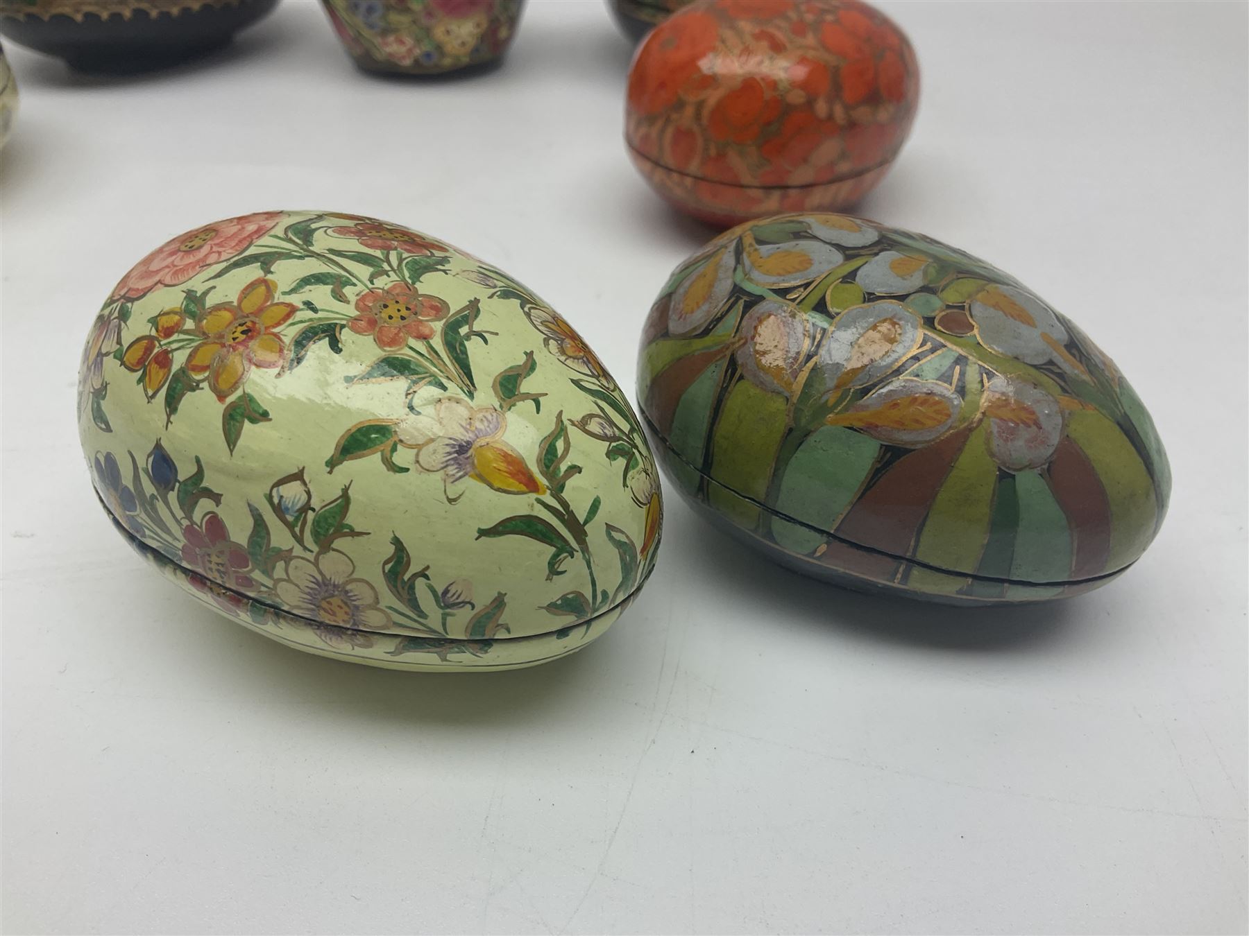 Seven lacquered boxes, of ovoid form, with floral decoration, largest H7cm, L10cm