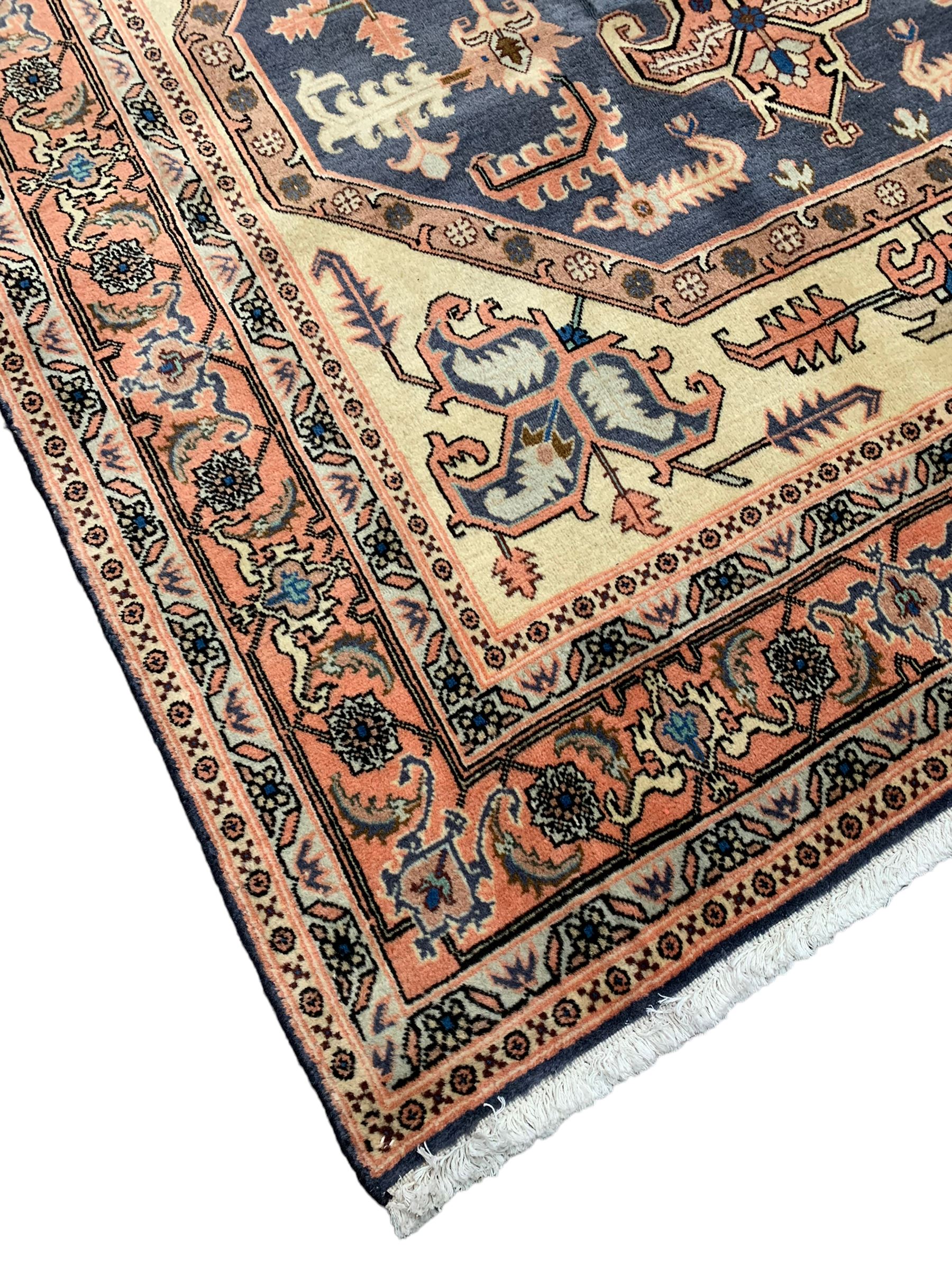 Persian ivory and peach ground, overall geometric design, the field with central star medallion surround stylised leaf motifs, guarded geometric design border