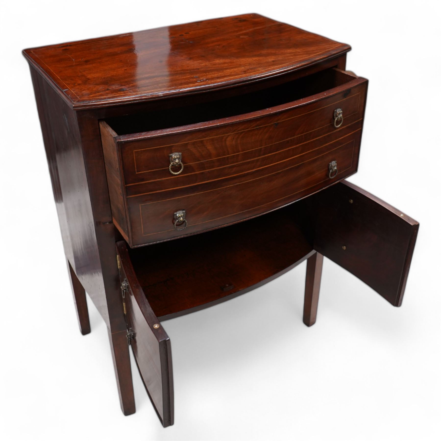 George III mahogany bow-fronted night cabinet, moulded top with box wood stinging over single drawer and double cupboard, with lion mask and hoop handles, on square supports 