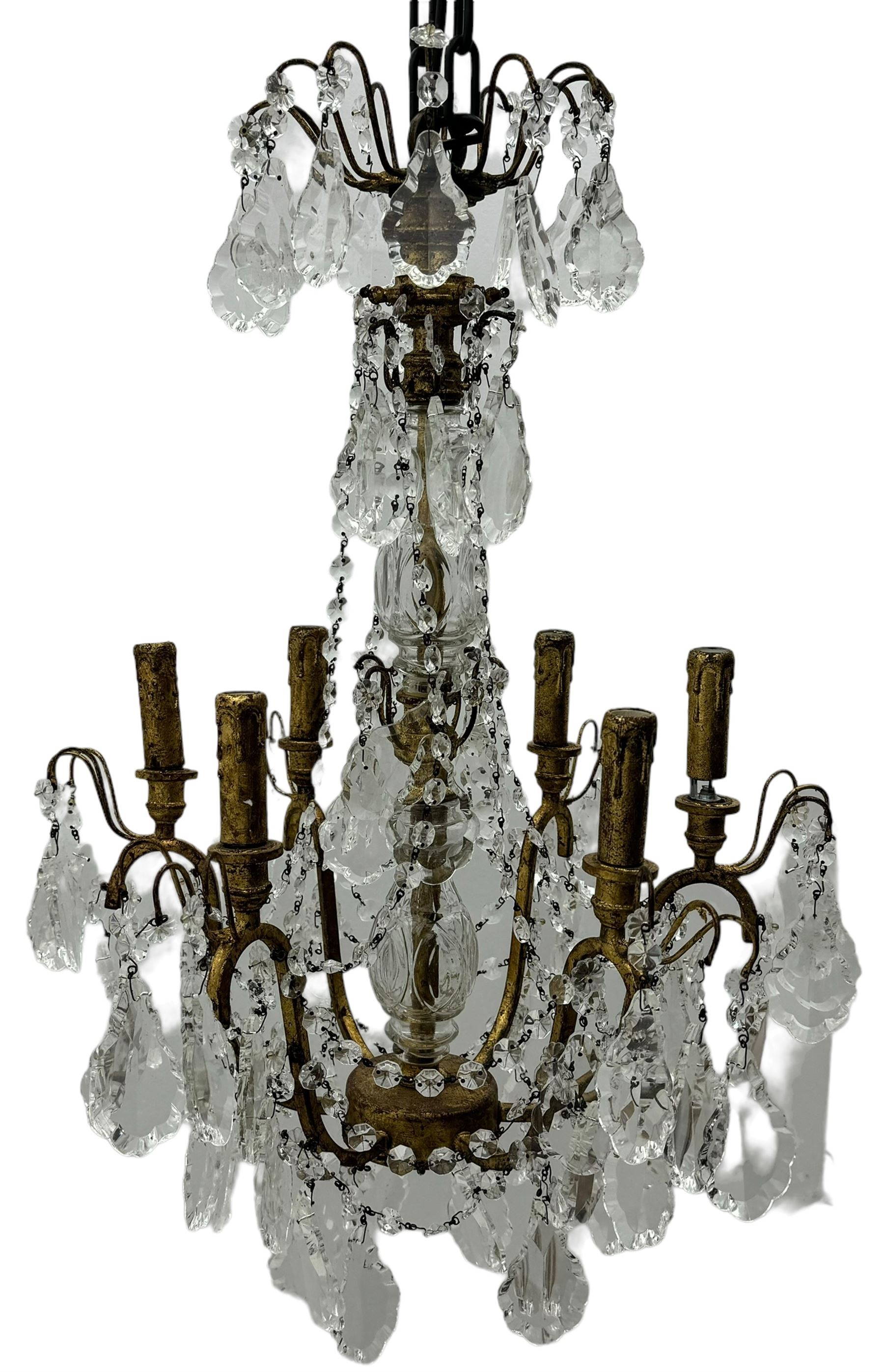 India Jane Interiors - brass and crystal six-branch chandelier, each branch holds a single candle-style bulb holder detailed with scrolling design, the chandelier is adorned with numerous crystal pendants and octagonal beads, which hang from each arm and from the cut crystal central column