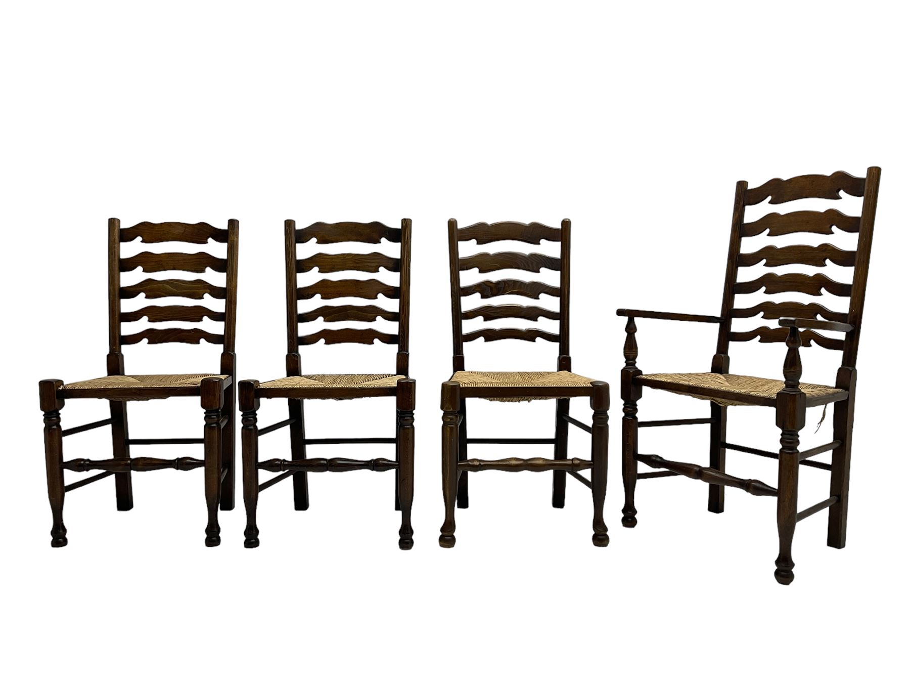 Matched set of eight (7+1) oak ladder back dining chairs, waved ladder back over rush seats, on turned supports joined by turned stretchers