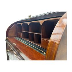 Edwardian inlaid mahogany roll-top desk, cylindrical lid enclosing fitted interior with pigeonholes, drawers and retractable writing surface, over two drawers with brass pull handles, on tapered supports with brass and ceramic castors