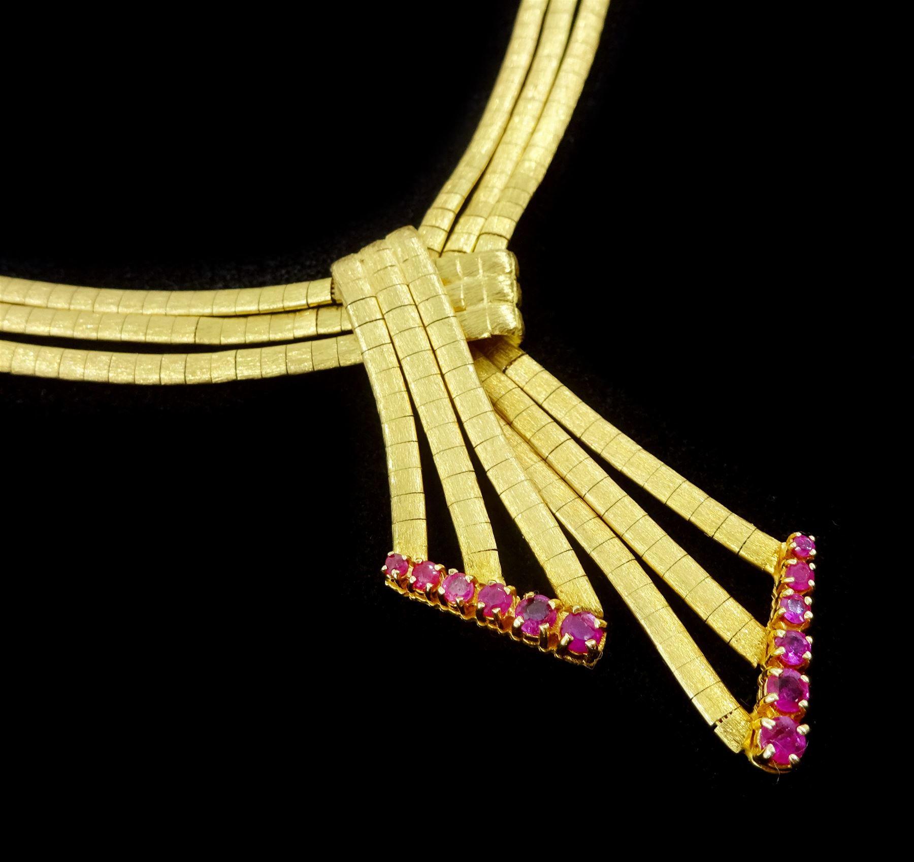 18ct gold three strand omega link chain necklace, with gradating ruby knot pendant, stamped 750