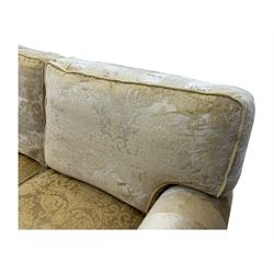 Contemporary two-seat sofa, upholstered in damask fabric with a pale gold floral pattern, rolled arms, loose back and seat cushions, on matching skirted base with concealed castors